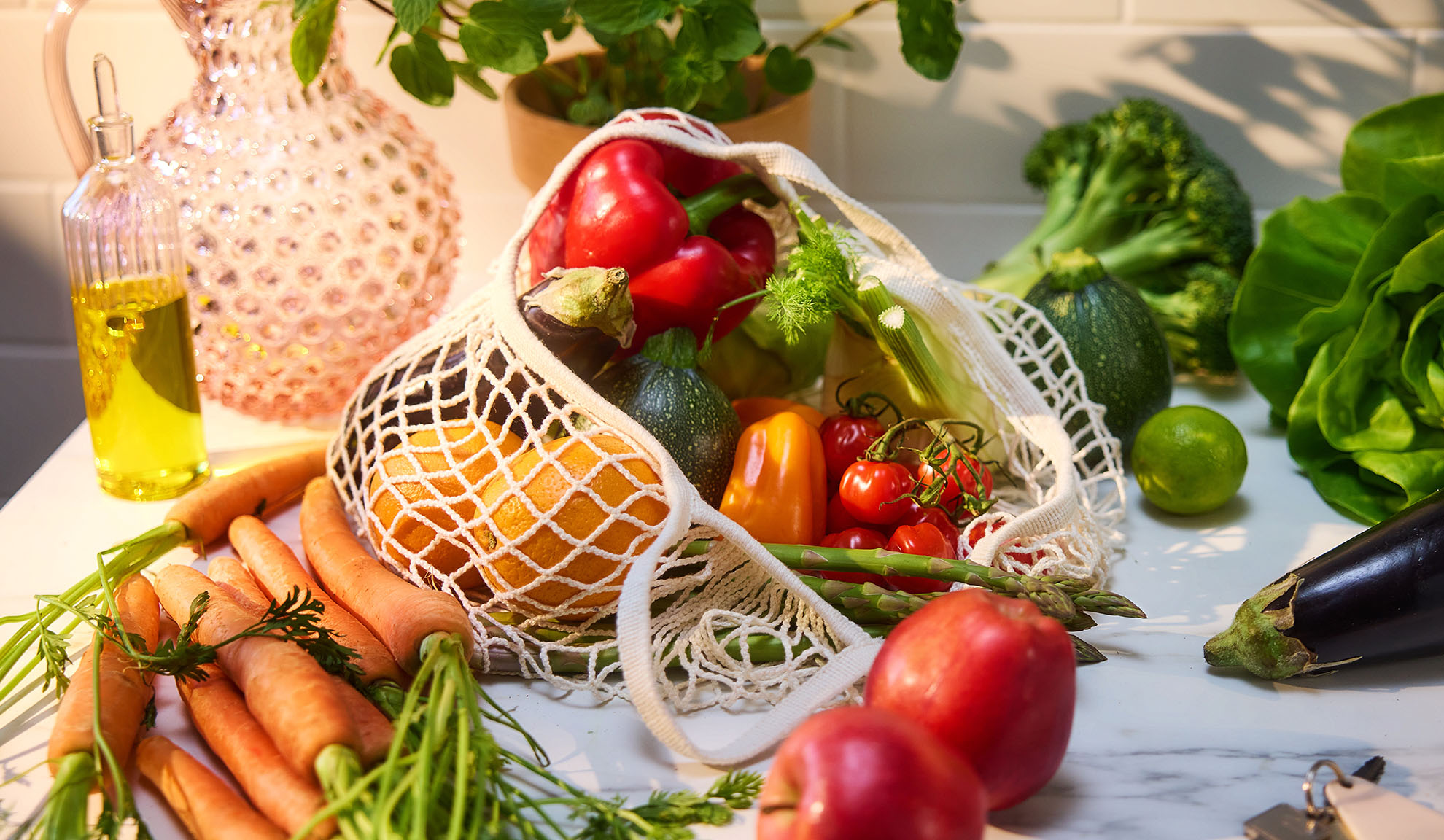 Légumes et fruits frais, dont poivrons, oranges et carottes, dans un sac de courses.