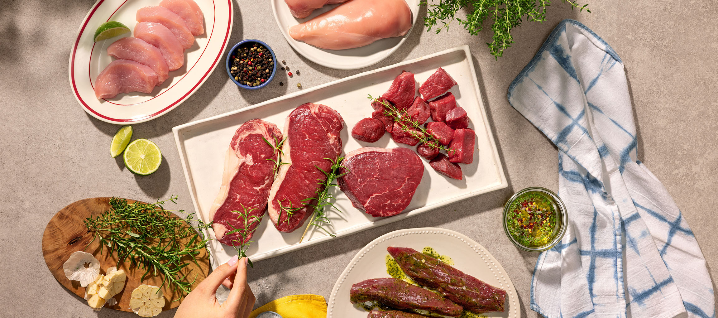 Diverses coupes de viande crue, y compris poulet et bœuf, avec herbes et épices.