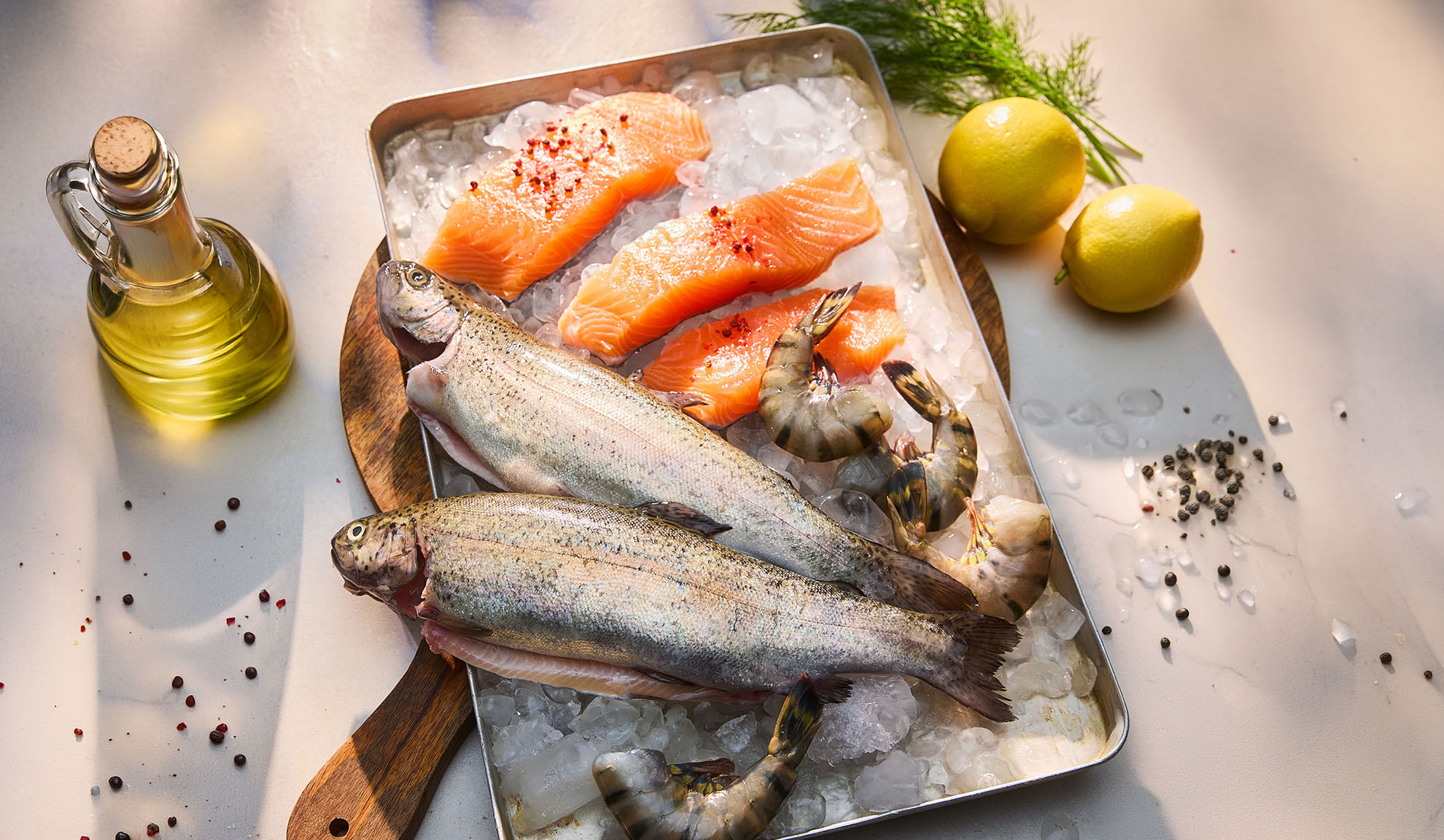 Poisson frais, filets de saumon et crevettes sur glace, avec citrons et huile.