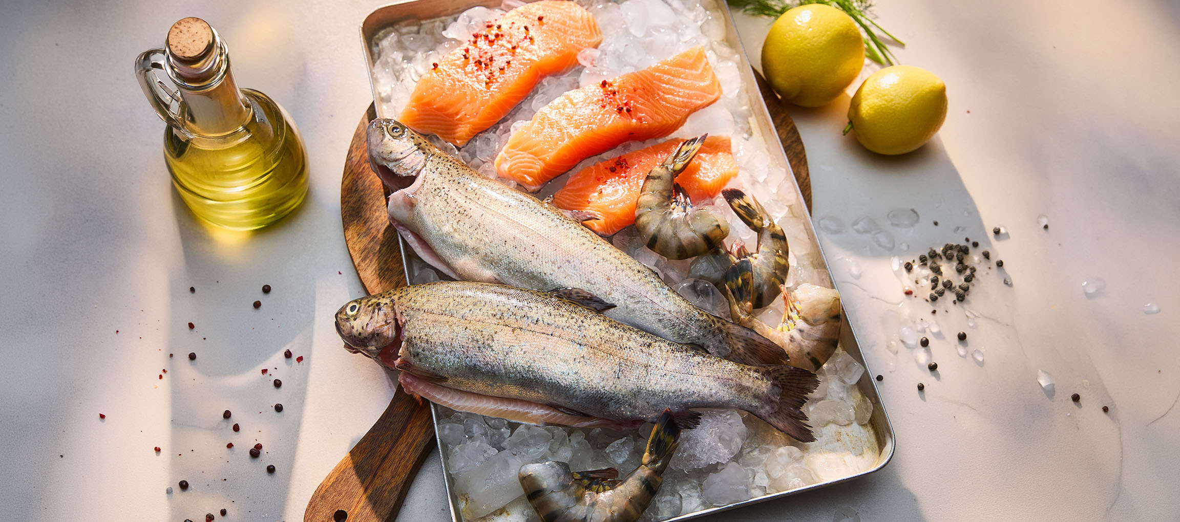 Poissons et fruits de mer frais sur glace, avec citrons et huile.