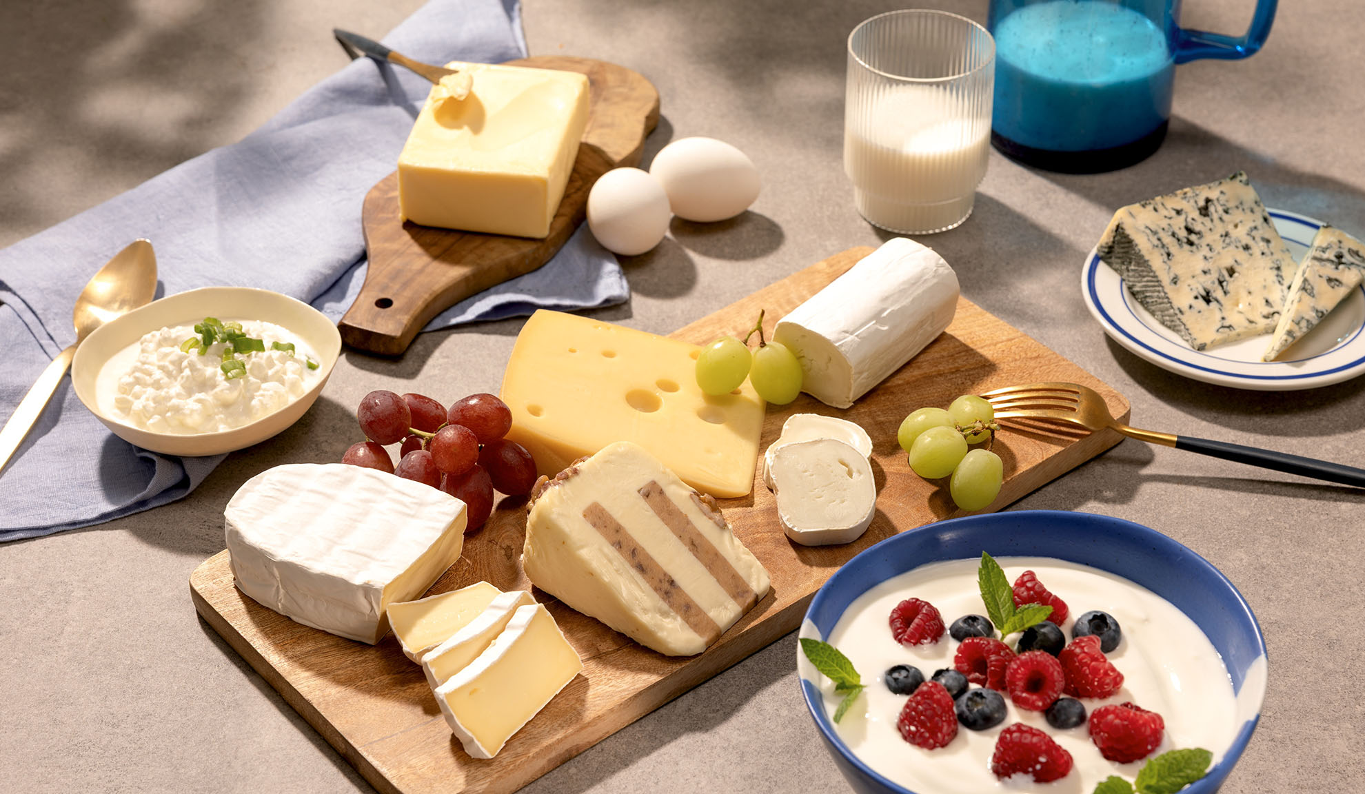 Une variété de fromages, de raisins et de produits laitiers comme le cottage cheese, le lait et le yaourt aux baies.