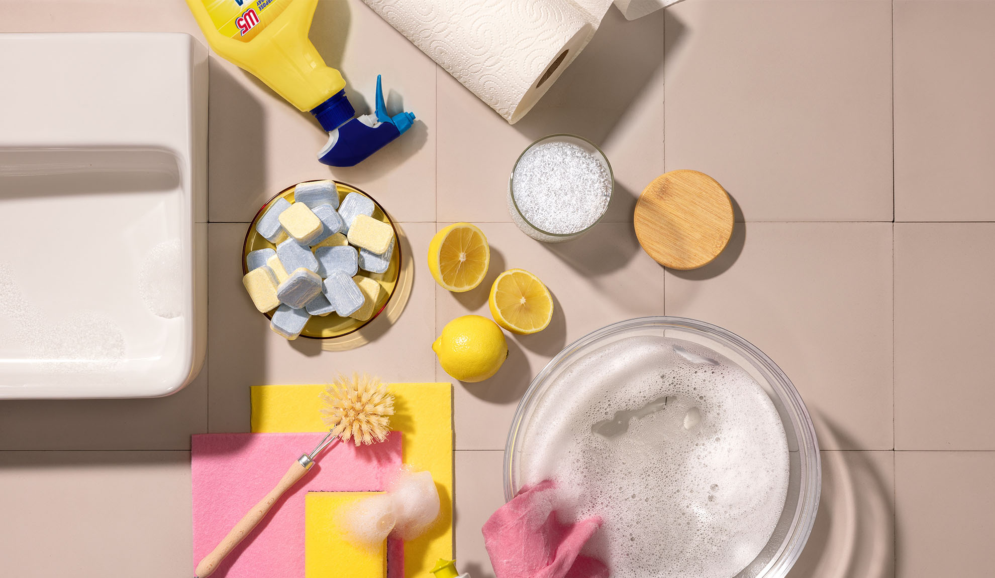 Produits de nettoyage ménagers, y compris détergent, éponges, citrons et tablettes lave-vaisselle.