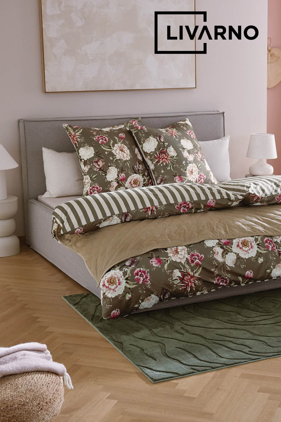 Lit double avec parure de lit fleurie vert olive et tapis assorti.