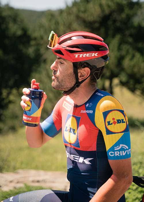 Cycliste Trek avec maillot Lidl buvant de l'eau.