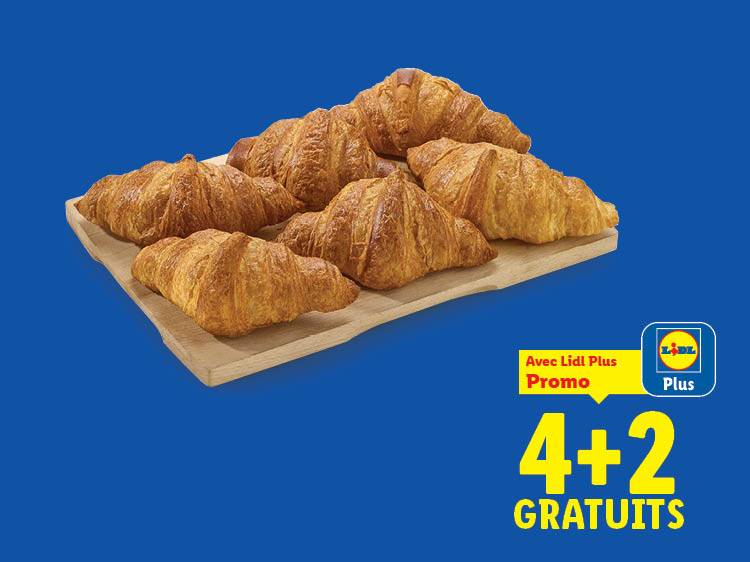 Six croissants dorés sur une planche en bois avec une offre promotionnelle 4+2 gratuits.