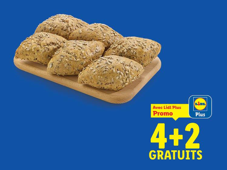 Six petits pains aux graines sur une planche en bois, avec une offre 4+2 gratuits.