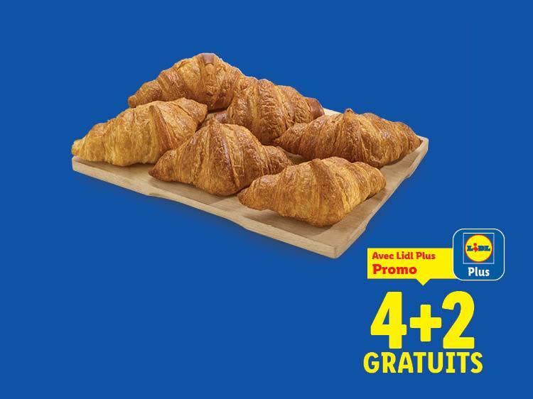 Six croissants dorés sur une planche en bois, avec une offre promotionnelle 4+2 gratuits.