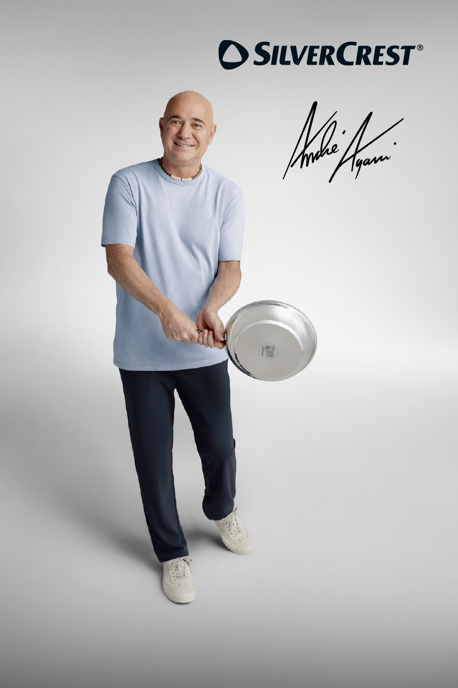 Un homme souriant tenant une poêle à frire, avec une signature manuscrite.
