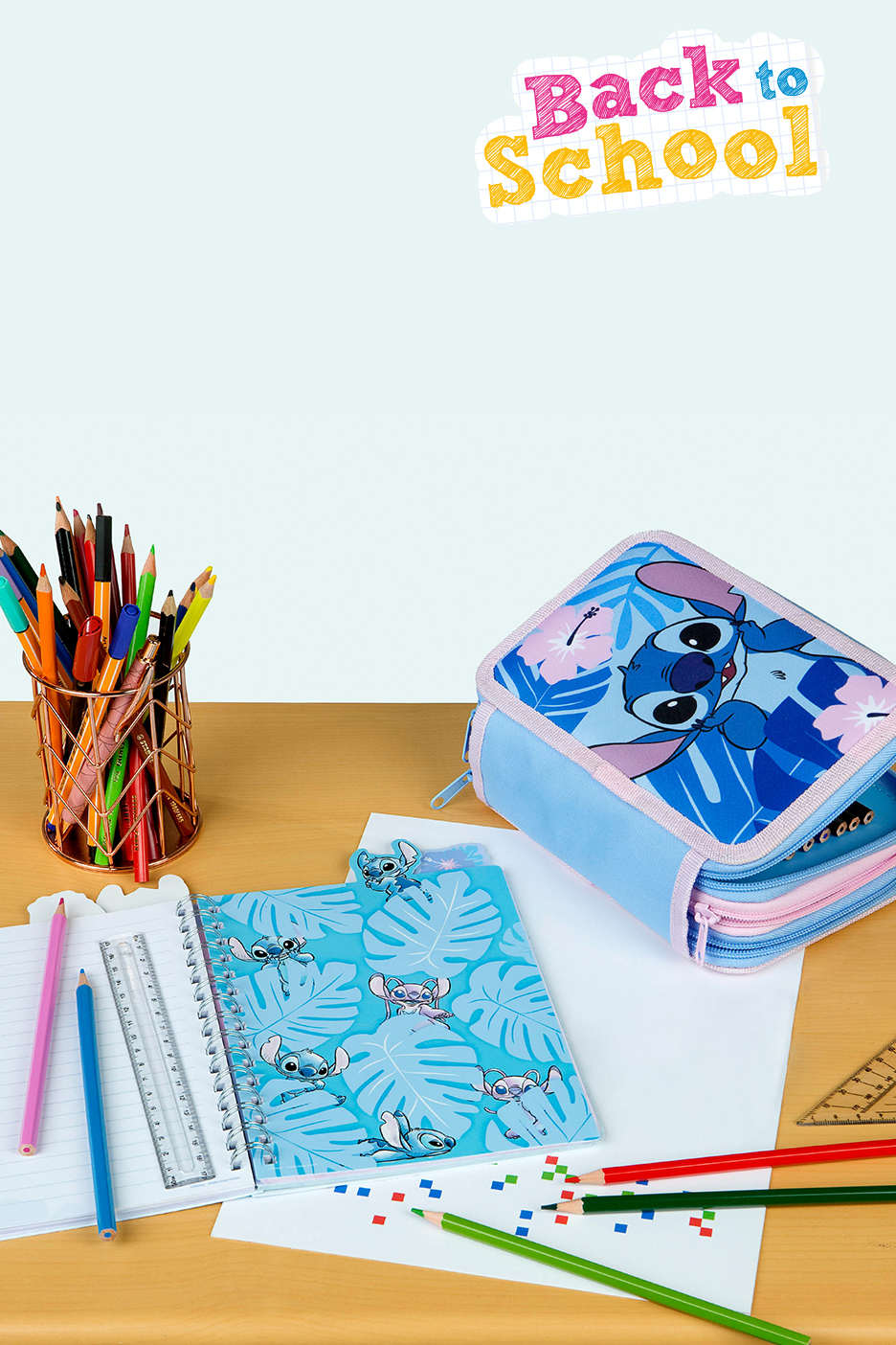 Fournitures scolaires sur le thème de Stitch, avec trousse, cahier et crayons.