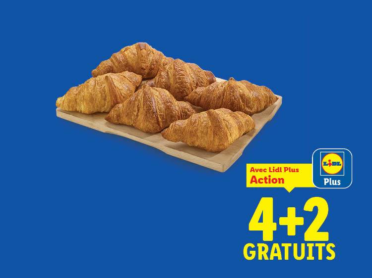 Sept croissants dorés sur une planche en bois, avec une offre 4+2 gratuits.