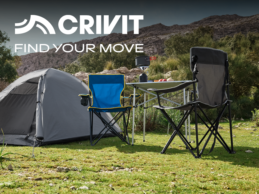 Tente de camping grise, deux chaises pliantes et une table avec réchaud en plein air.