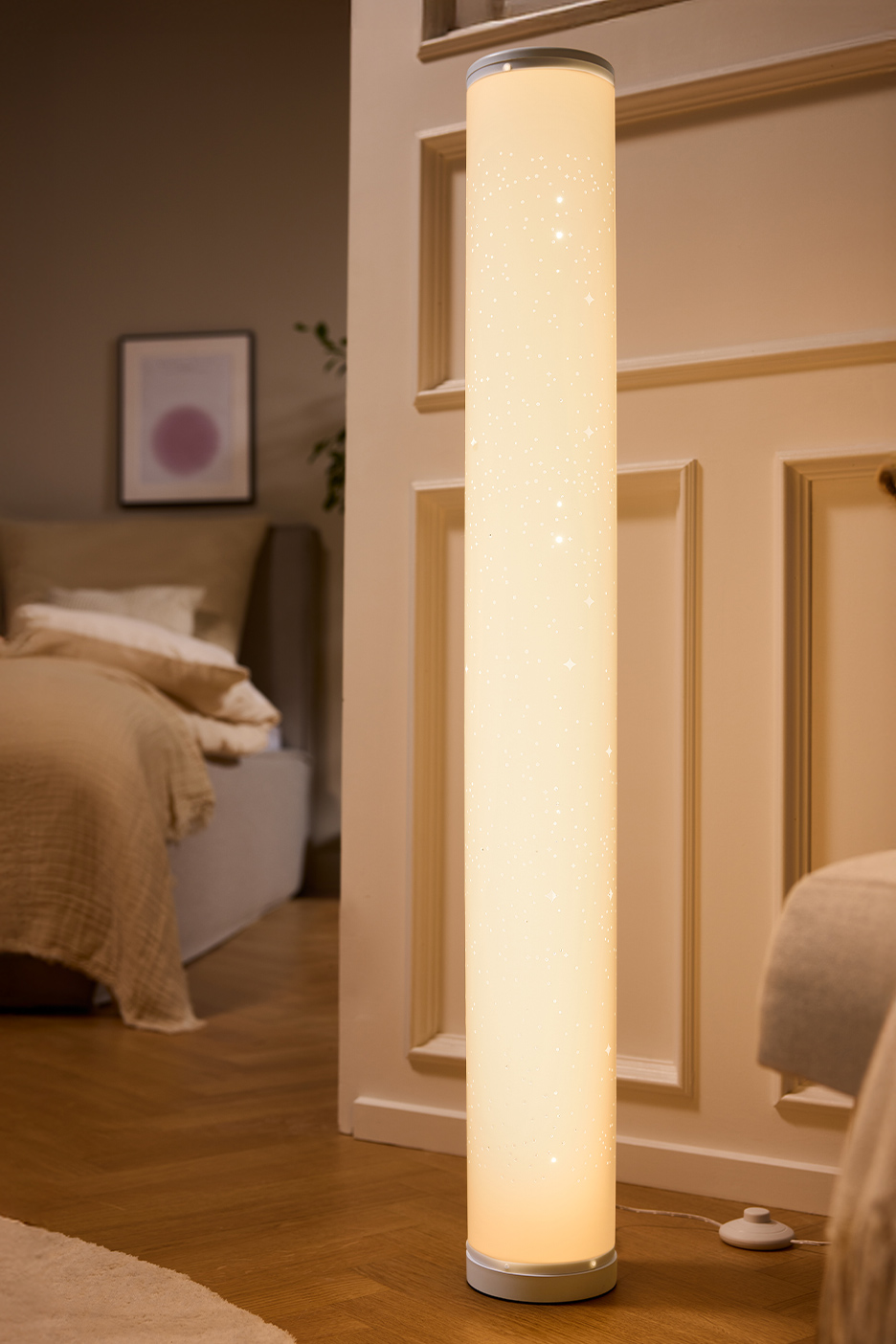 Lampadaire cylindrique lumineux avec motif étoiles dans une chambre à coucher