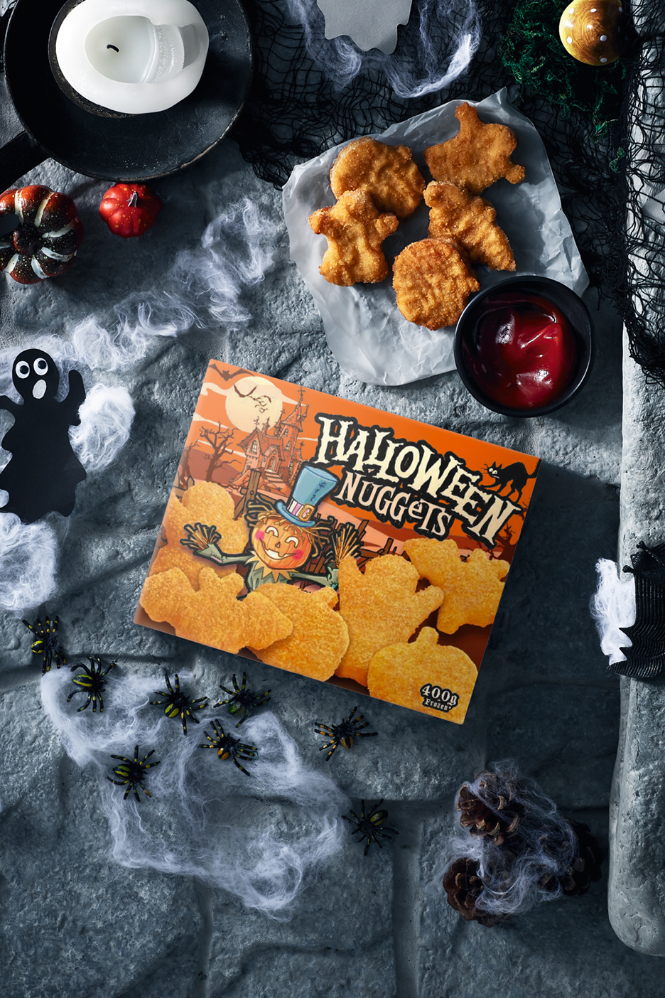 Nuggets d'Halloween avec ketchup, bougie et décorations effrayantes sur fond de pierre.