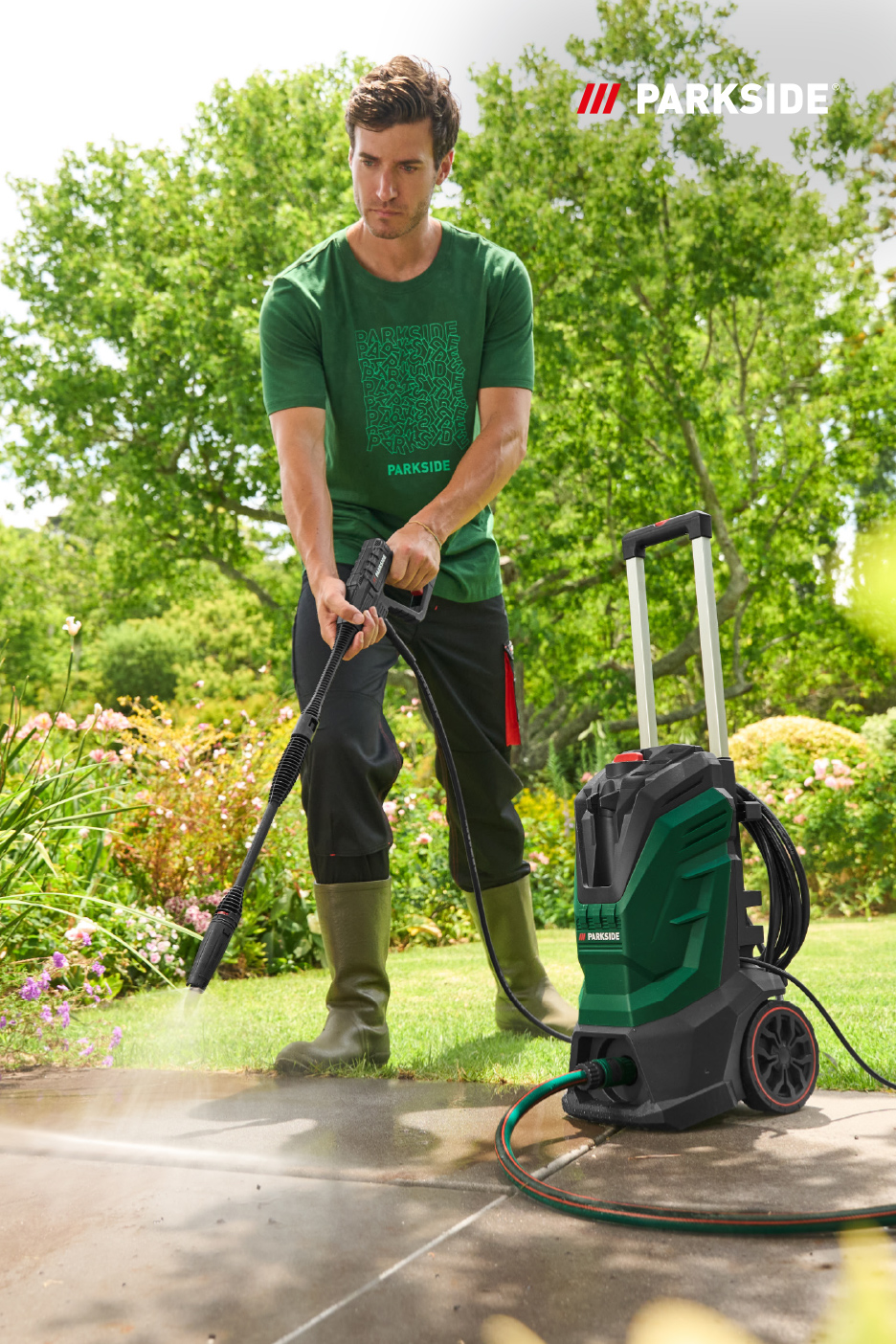 Un homme utilise un nettoyeur haute pression pour nettoyer une allée de jardin.