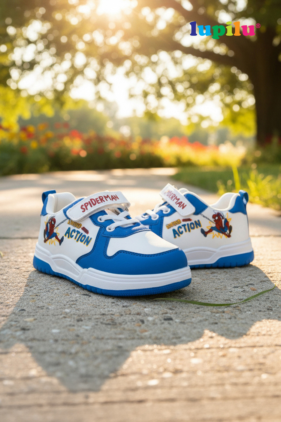 Baskets blanches et bleues pour enfants avec motif Spiderman, sur un chemin ensoleillé.