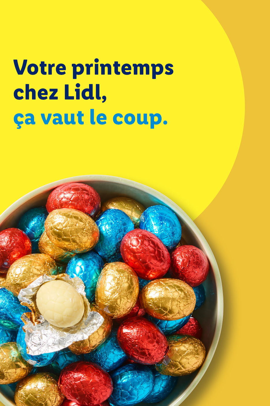 Un bol rempli d'œufs de Pâques en chocolat emballés, avec un œuf blanc ouvert. Texte : Votre printemps chez Lidl, ça vaut le coup.