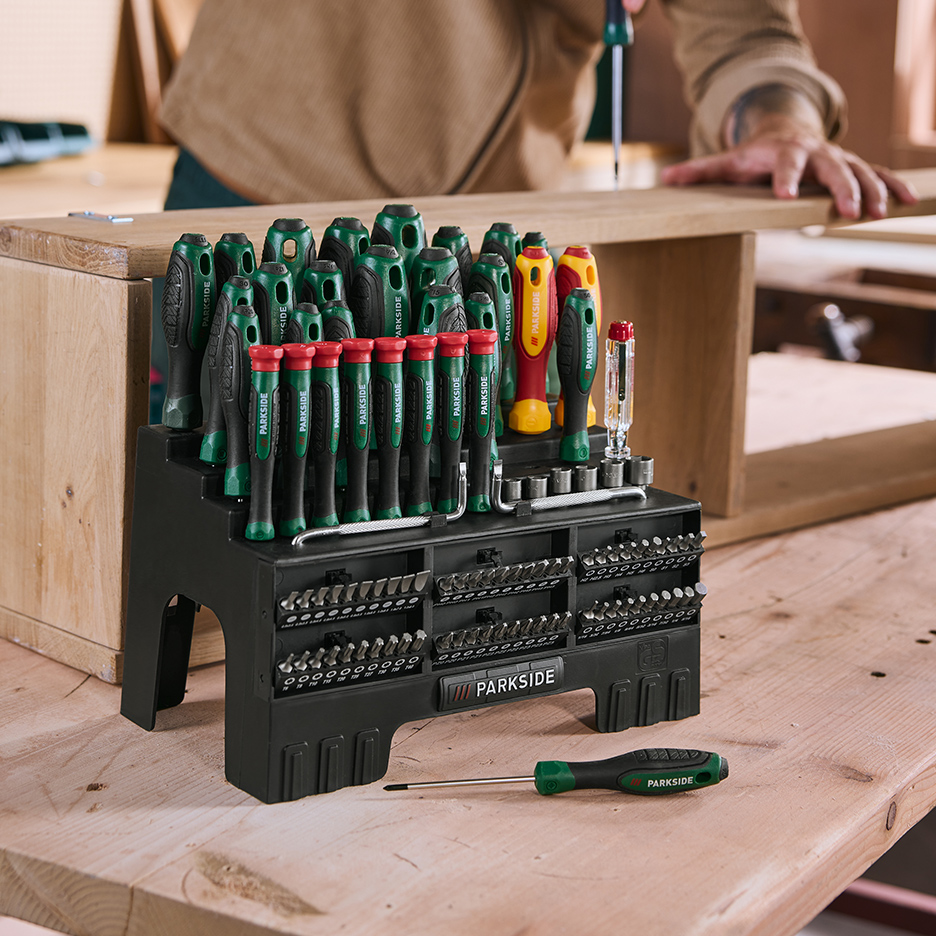 Un ensemble d'outils Parkside avec tournevis et embouts sur un établi en bois.