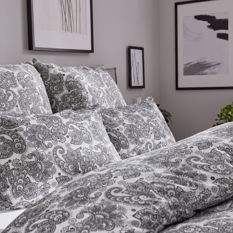 Parure de lit à motif cachemire gris et blanc dans une chambre moderne.