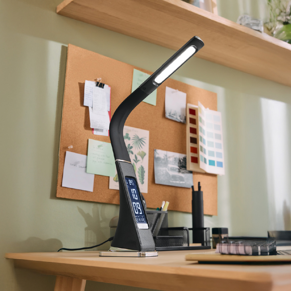 Lampe de bureau LED noire avec écran numérique sur un bureau en bois avec un tableau d'affichage.