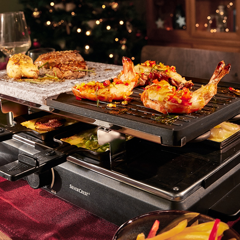 Raclette SilverCrest avec crevettes et viande grillées, ambiance de Noël.