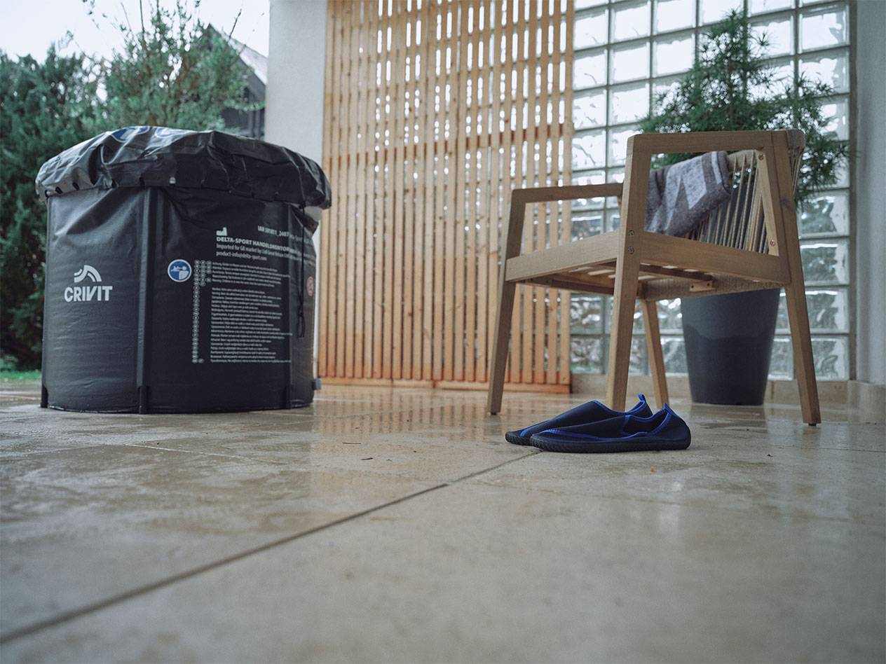 Piscine gonflable Crivit et chaussures d'eau sur une terrasse.