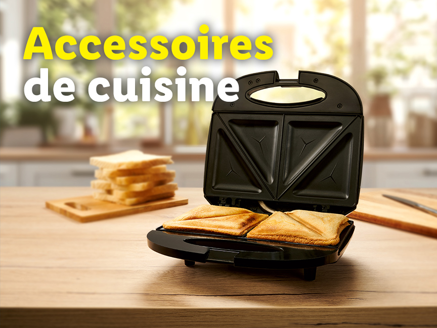 Un appareil à sandwichs noir sur une table en bois, avec du pain grillé à côté. Accessoires de cuisine.