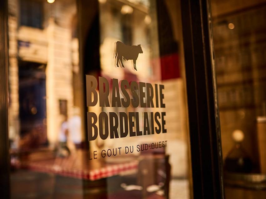 Enseigne de la Brasserie Bordelaise avec une silhouette de vache et le texte 'Le Goût du Sud-Ouest'.