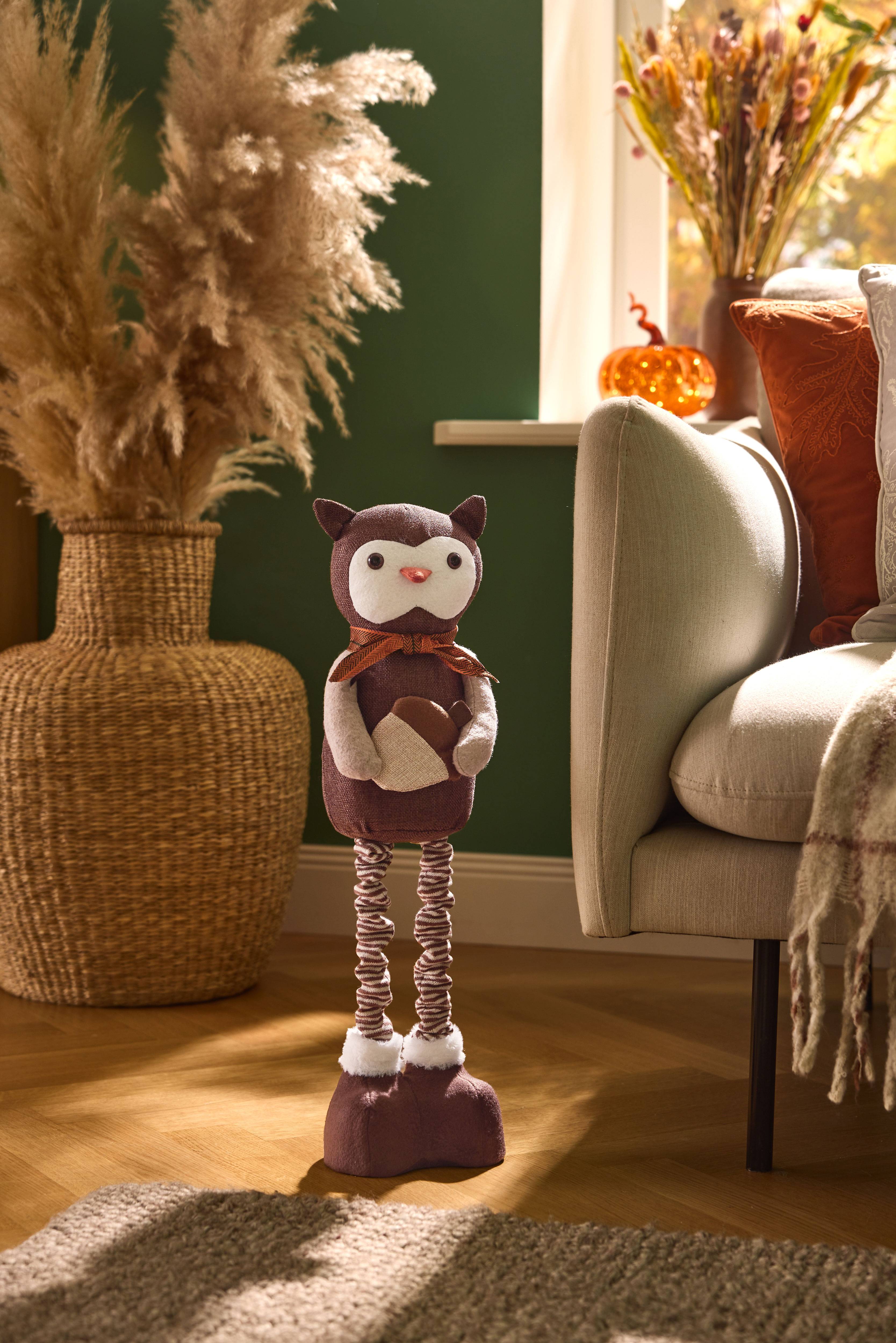 Décoration d'automne : ornement hibou, fleurs séchées et coussins sur le canapé.