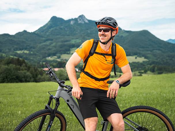 Vélo électrique et cycliste dans un paysage montagneux.