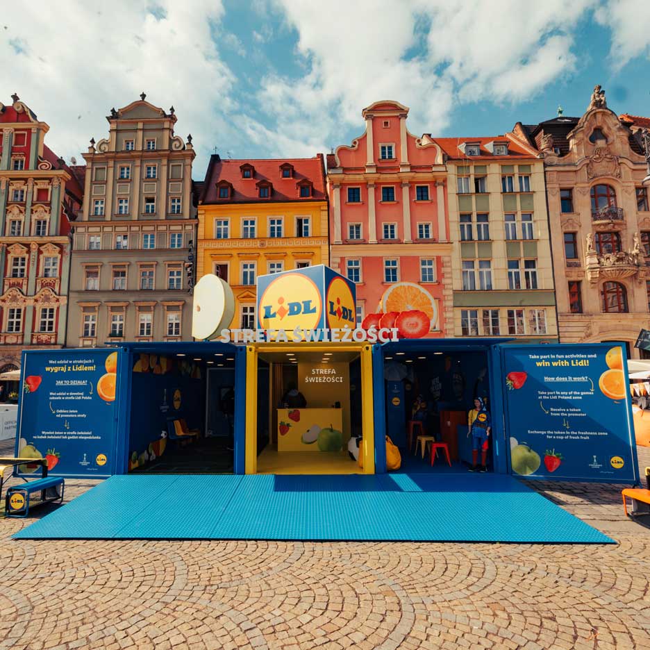 Une installation Lidl sur le thème des fruits et légumes, avec jeux et activités, sur une place urbaine.
