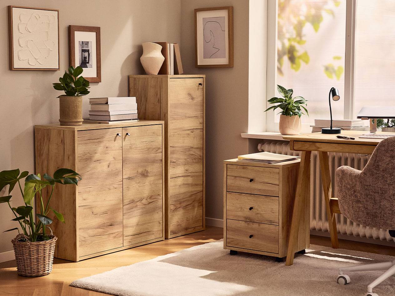 Un bureau à domicile avec des armoires en bois clair, une chaise de bureau et une lampe de bureau.