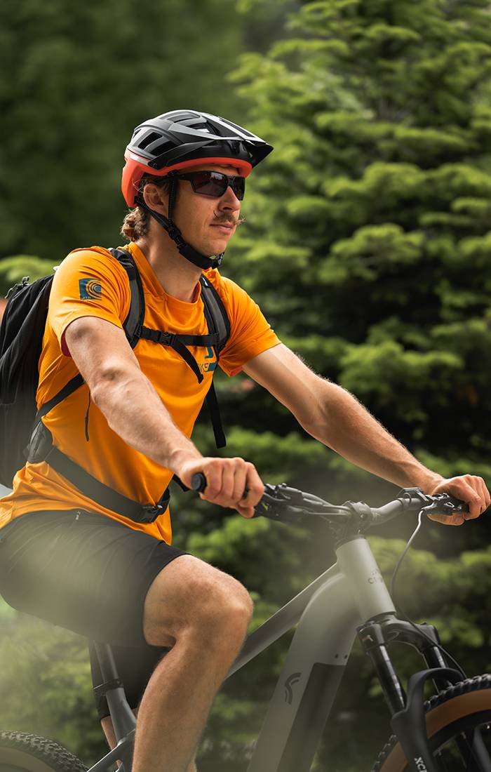 Homme faisant du VTT, portant un casque et des vêtements de sport.