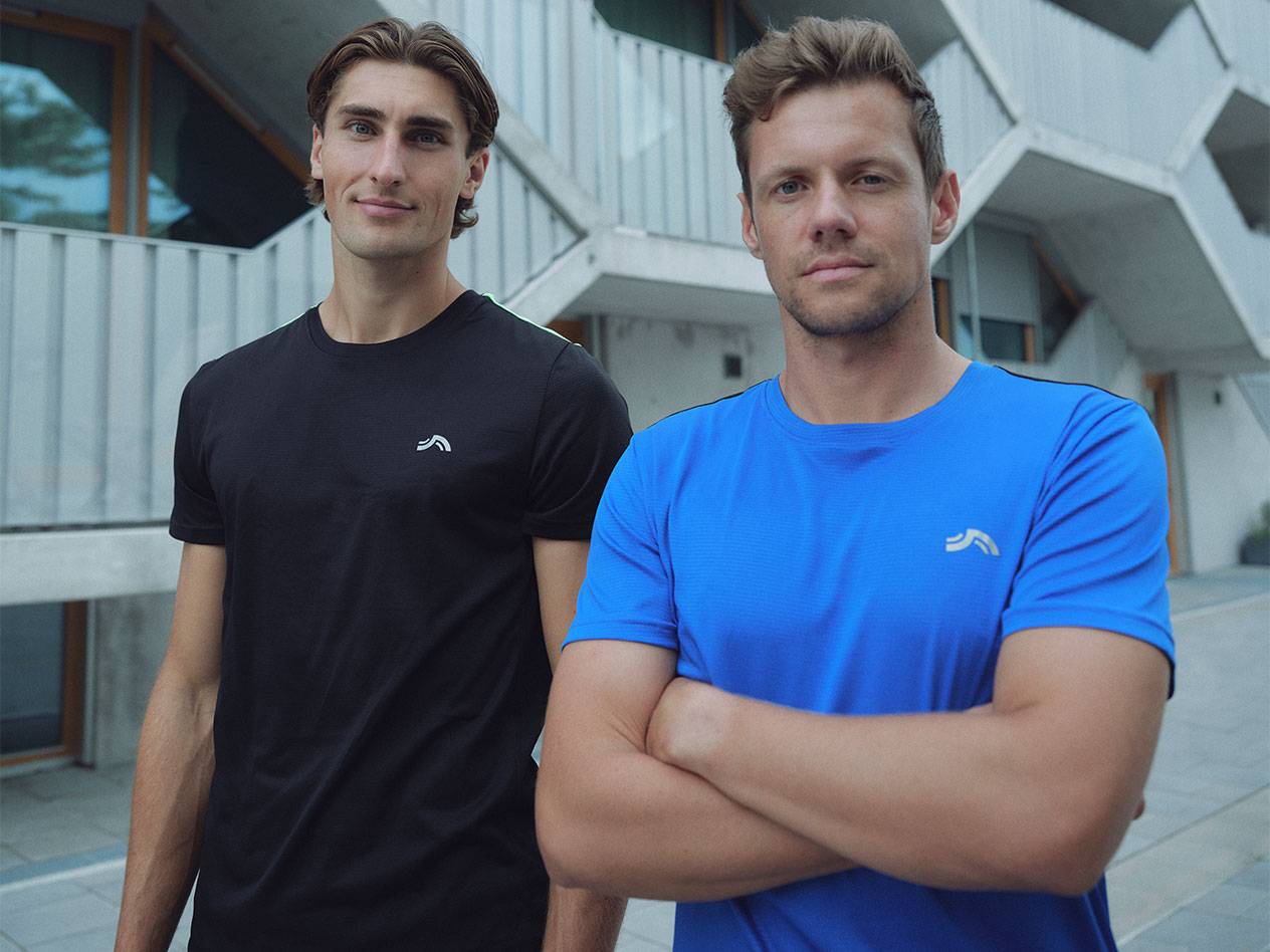 Deux hommes en t-shirts de sport noirs et bleus avec logo.