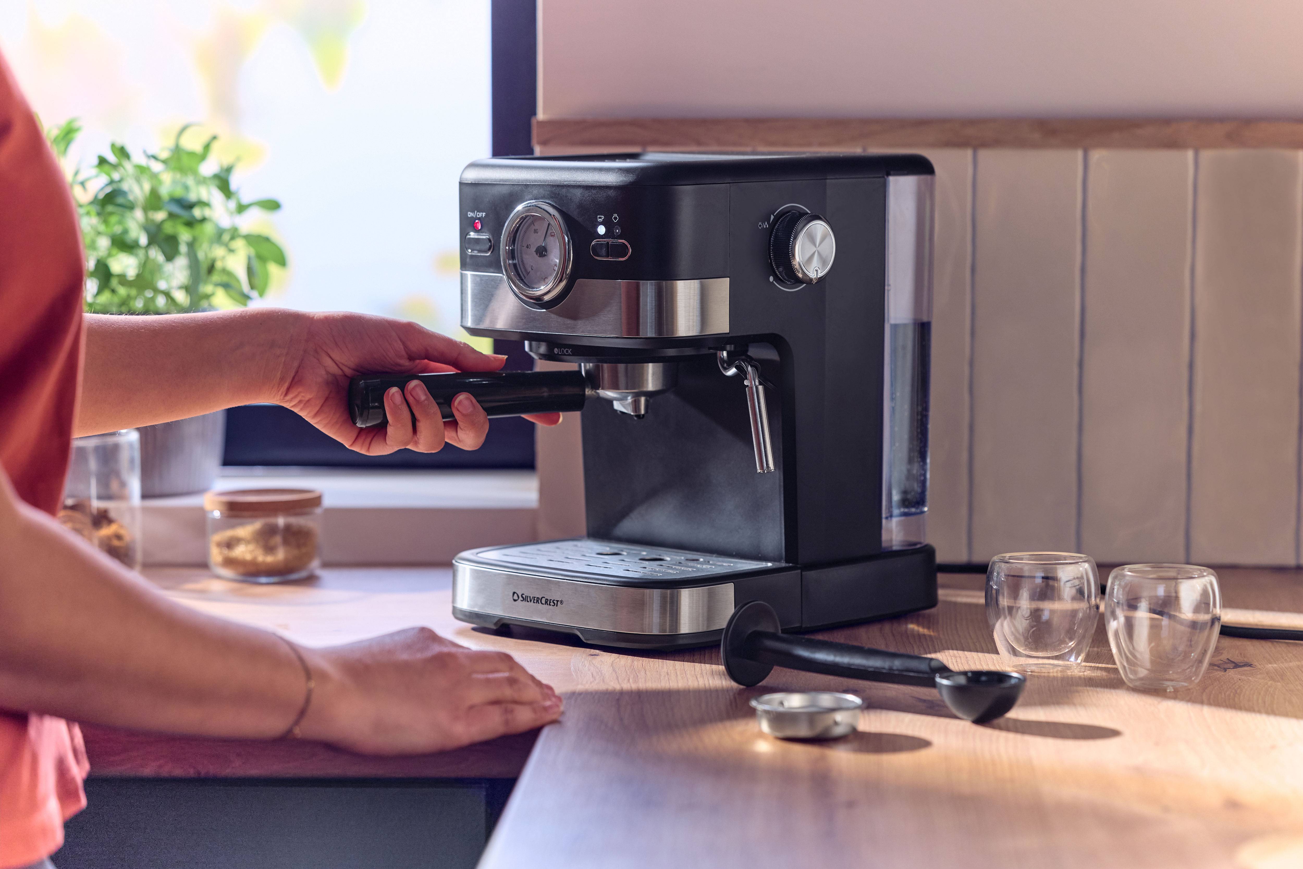 Machine à expresso sur un comptoir en bois, personne insérant le porte-filtre.