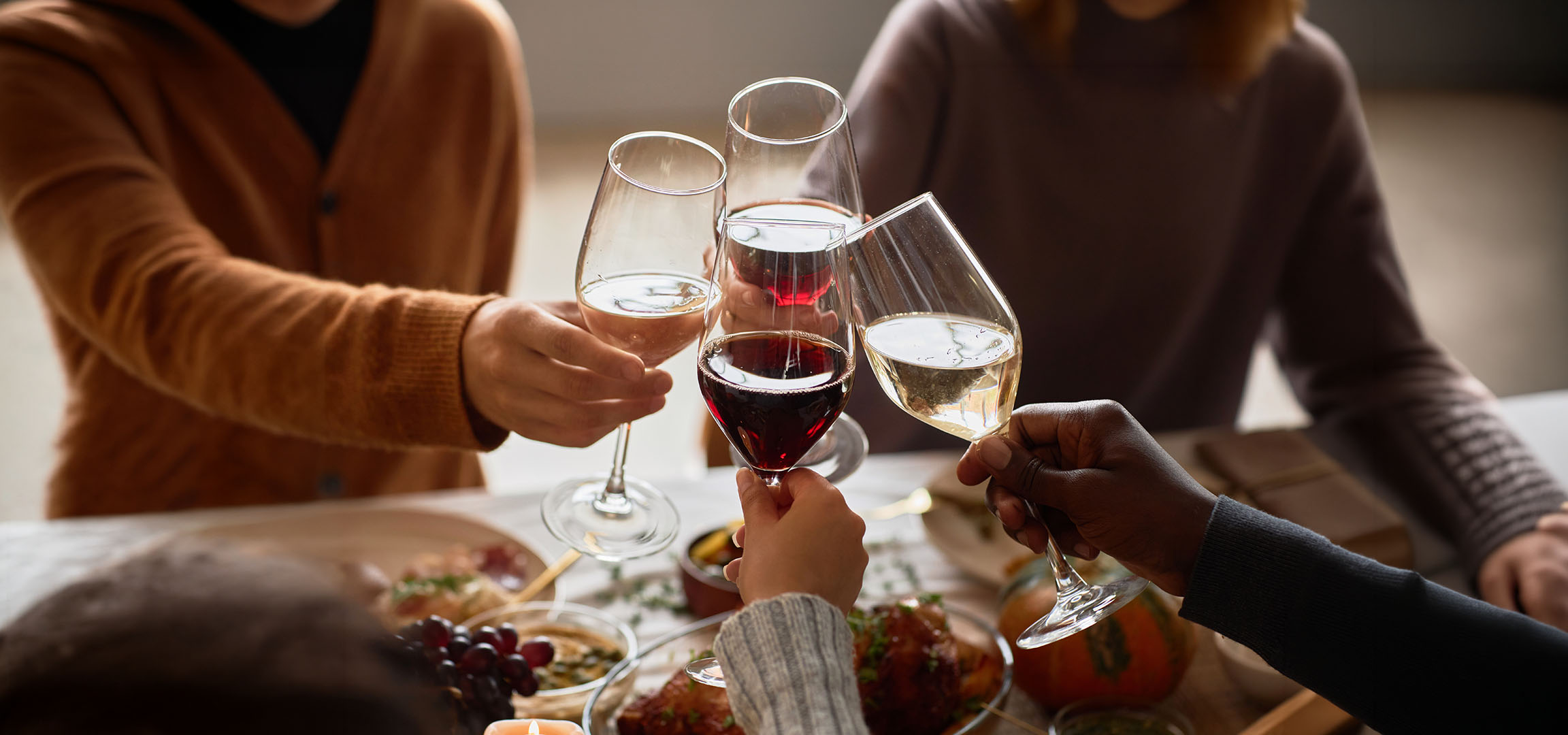 Personnes trinquant avec des verres de vin rouge et blanc.