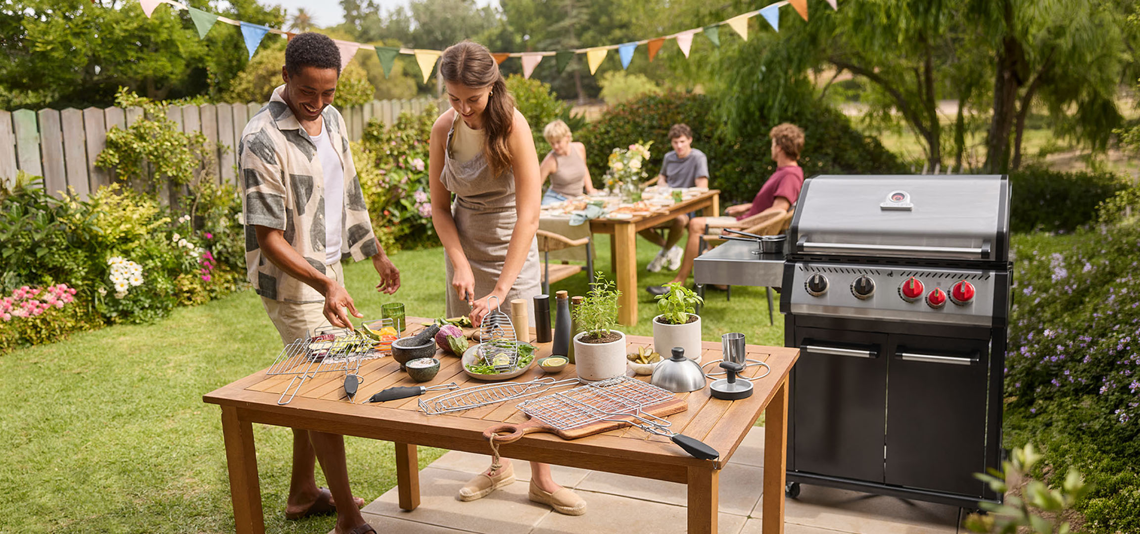 Personnes préparant des aliments sur un barbecue dans le jardin, avec grill à gaz et table.