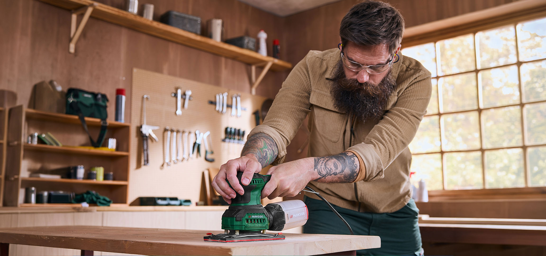 Généré par IA: Homme avec ponceuse électrique ponçant une table en bois dans un atelier.