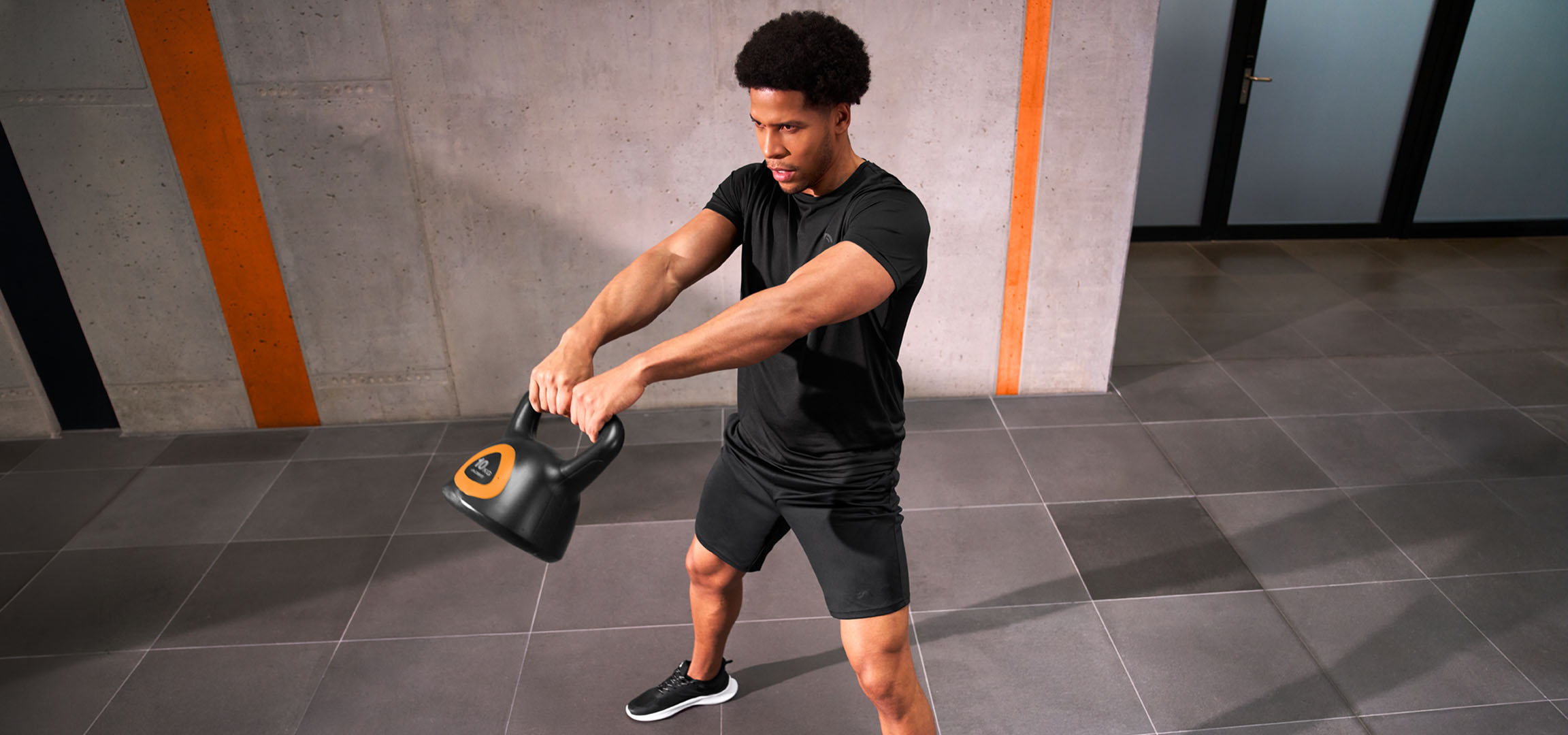 Généré par IA: Homme s'entraînant avec un kettlebell noir et orange.