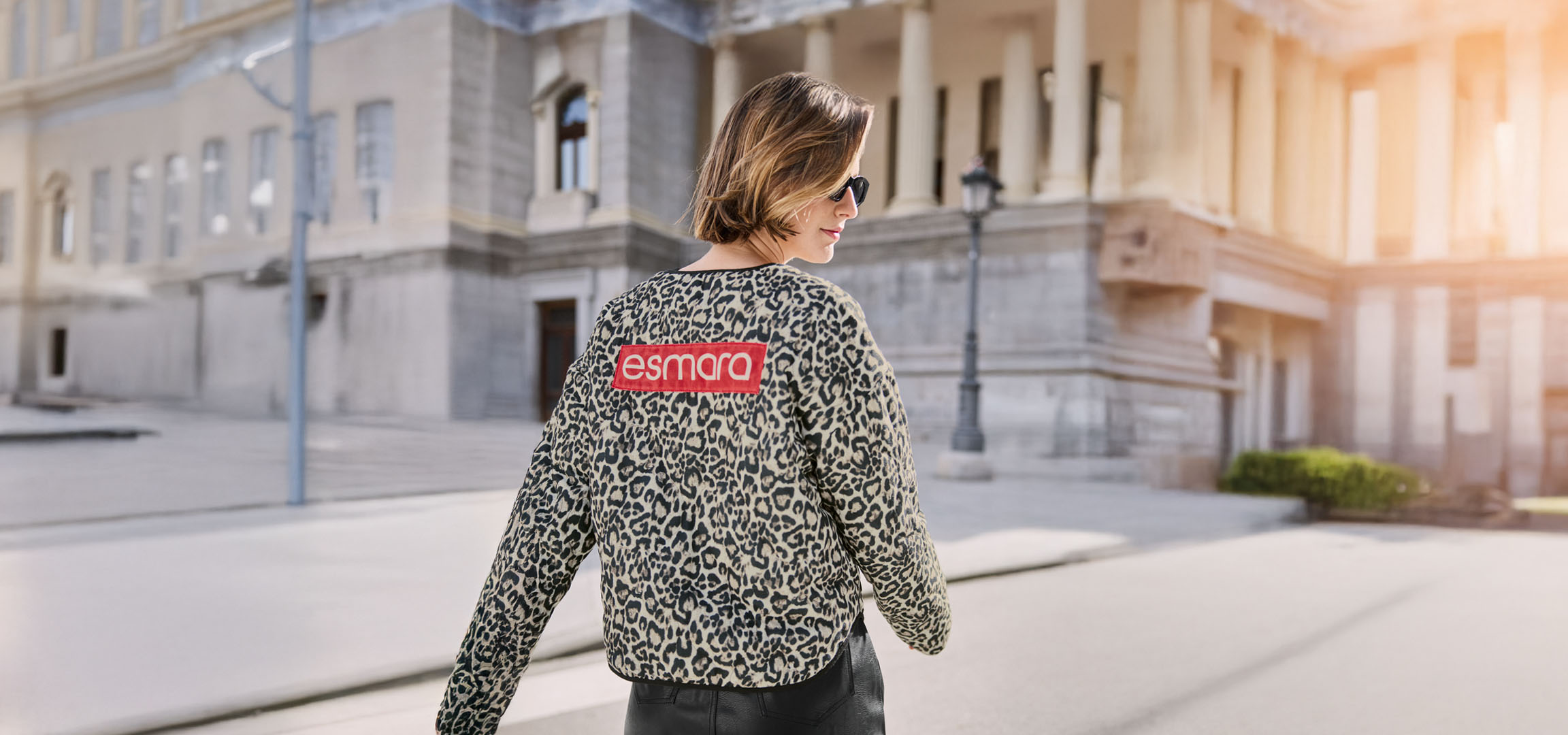 Femme en veste léopard Esmara, lunettes de soleil, dans une rue urbaine.