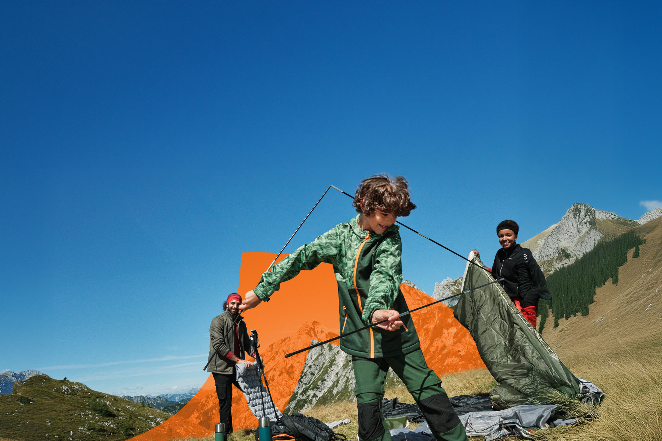 Famille montant une tente en montagne, avec équipement de camping et vêtements d'extérieur.