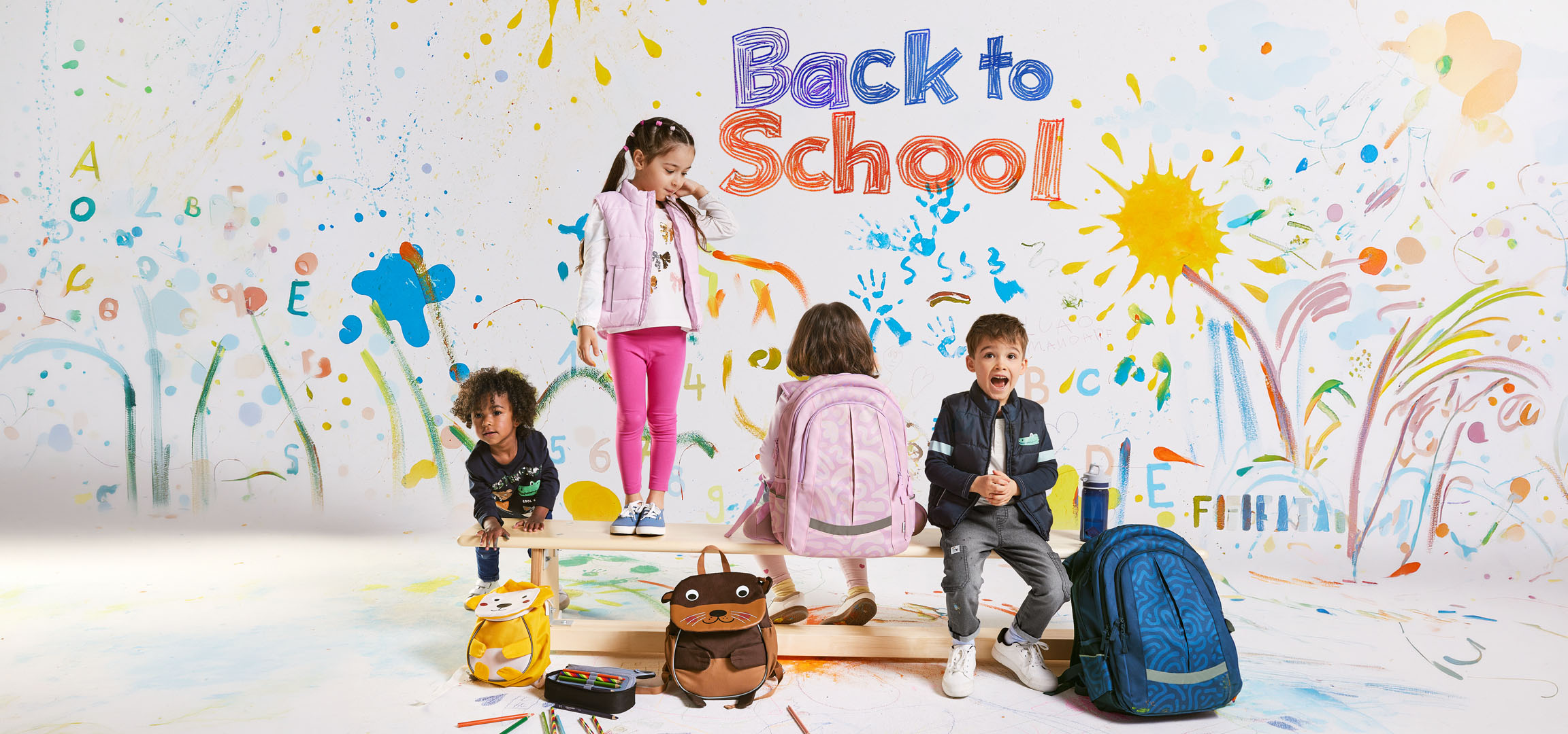 Enfants avec sacs à dos et fournitures scolaires sur fond de dessins colorés « Retour à l'école ».