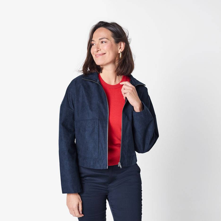 Femme en blouson aviateur bleu foncé et pull rouge